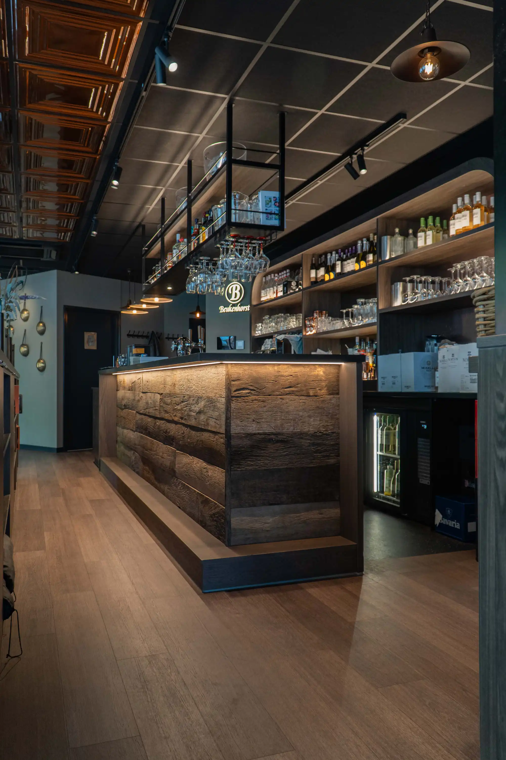 Bar mit authentischen Altholz-Eichenpaneelen in einem stilvollen Gastronomieinterieur.