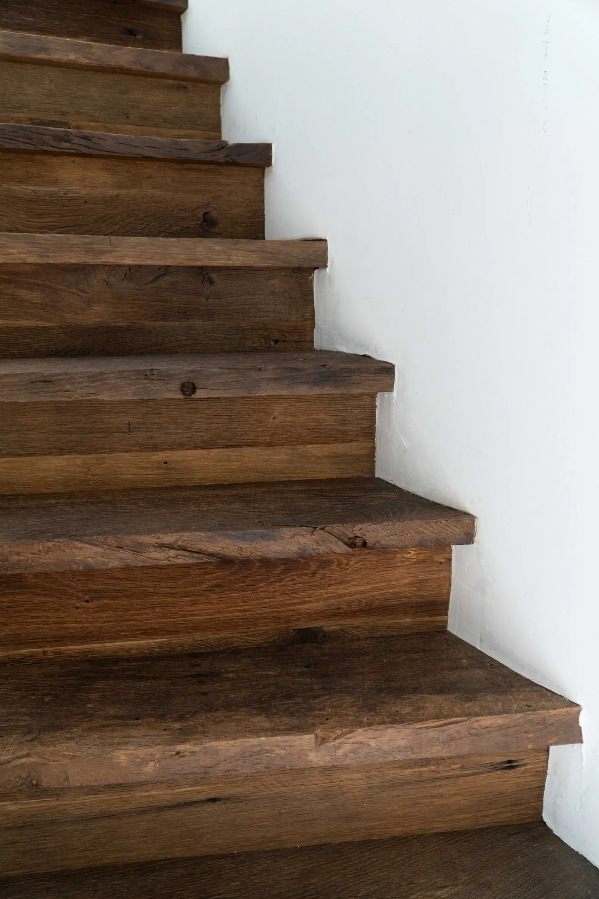 Treppe aus altem Eichenholz mit natürlicher Struktur und warmen Farbtönen in einem modernen Wohninterieur.