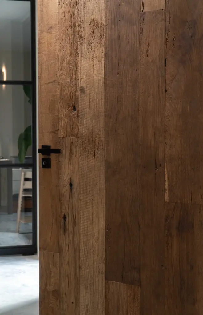 Tür aus altem Eichenholz mit natürlicher Maserung und authentischem Charakter in einem modernen Wohninterieur.