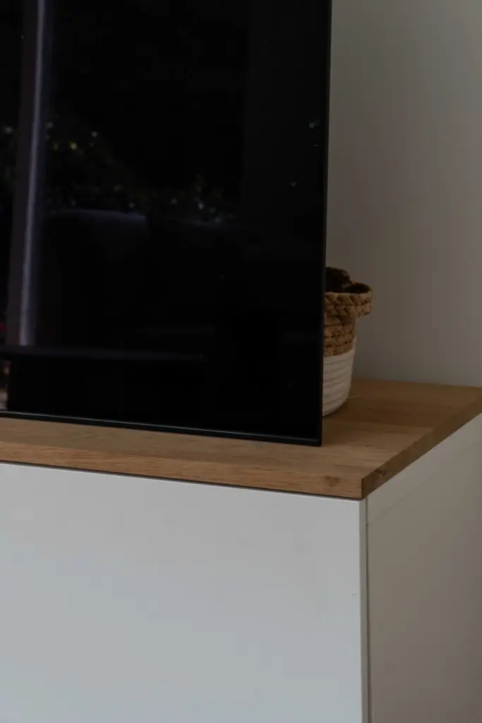 Detail eines maßgefertigten TV-Möbels mit einer Abdeckung aus alter Eiche in einem modernen Bauernhaus.