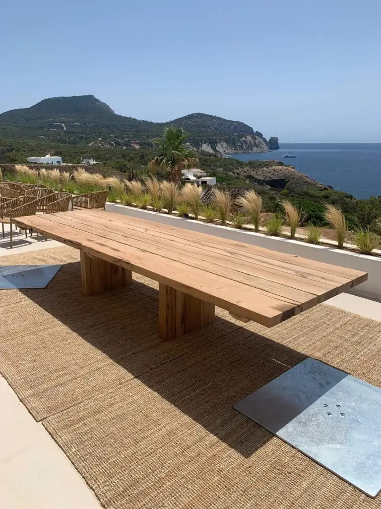 Großer Esstisch aus Altholz-Eiche auf einer sonnigen Terrasse mit Meerblick