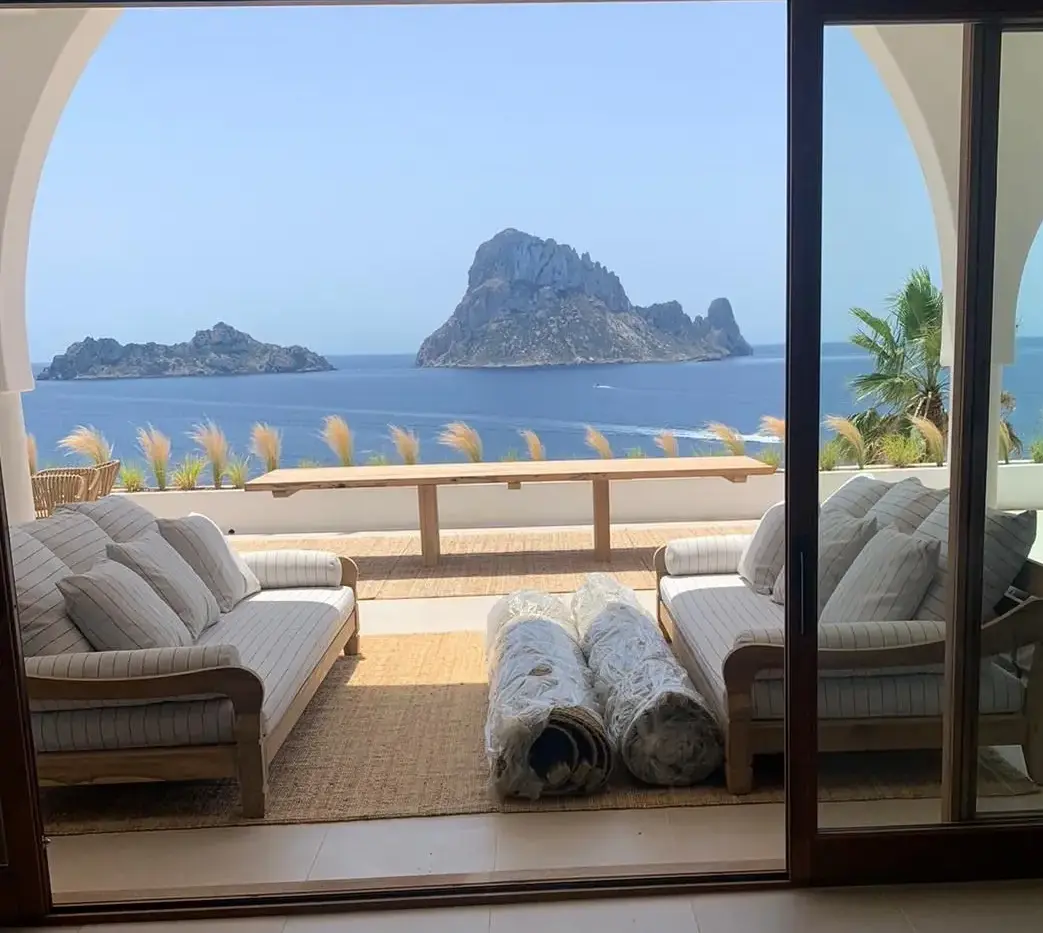 Großer Esstisch aus Altholz-Eiche auf einer sonnigen Terrasse mit Blick auf das Meer