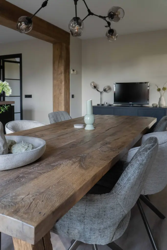 Großer Esstisch aus Altholz-Eiche mit markanter, natürlich gealterter Oberfläche und gepolsterten Stühlen in einem modernen Wohnraum.