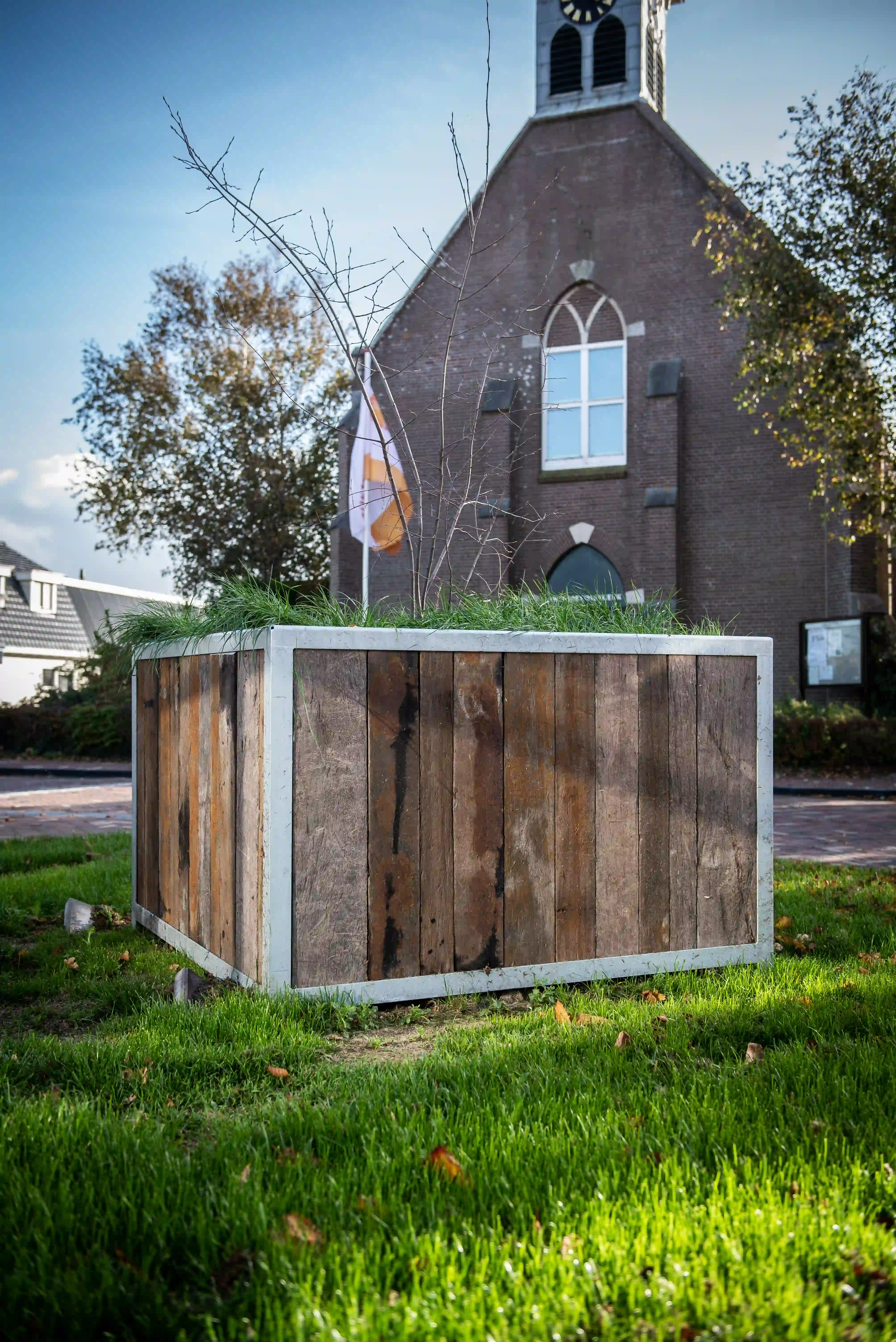 Pflanzkübel aus alten Azobé-Schiffsplanken in einem grünen Park in Den Helder